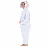 A young child dressed in a bunny costume, including a hooded white jumpsuit and pink ears, is smiling and holding a carrot.