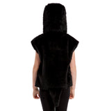 A person wearing a black furry hooded jacket stands facing away from the camera.